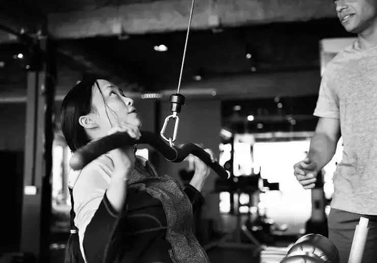 Woman training with a personal coach in Singapore during a guided fitness workout focused on strength and wellness.